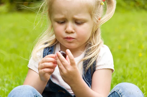 Маленькая девочка ест вишню на природе — стоковое фото