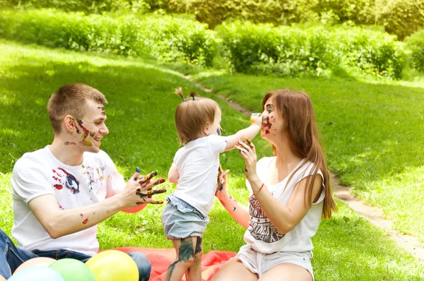 Família descansando na natureza. Pintura cores uns aos outros — Fotografia de Stock