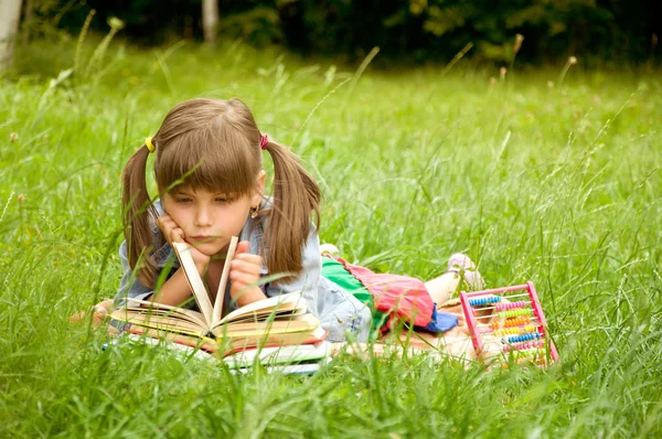 Pequeño alumno leyendo libros — Foto de Stock
