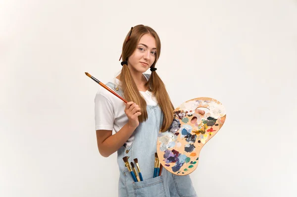 Mladý umělec držení štětce na malování a palety. — Stock fotografie