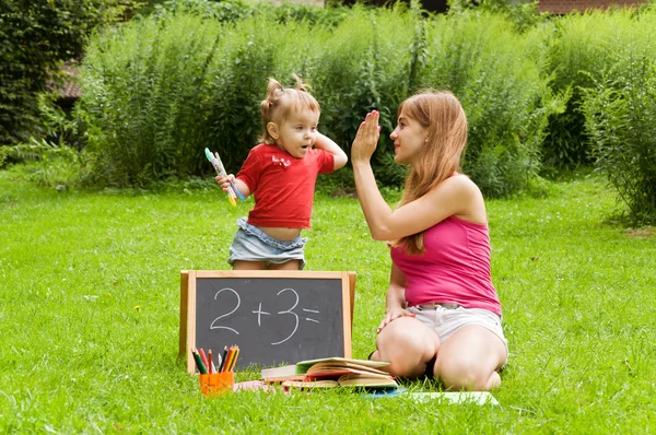 Madre enseña cartas a sus hijos pequeños — Foto de Stock