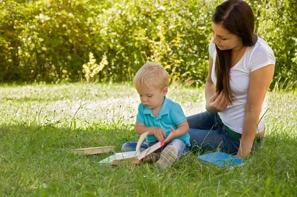 Anya szól, hogy gyermekei egy érdekes könyvet — Stock Fotó