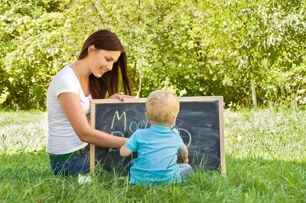 Mãe ensina seus filhos pequenos cartas — Fotografia de Stock