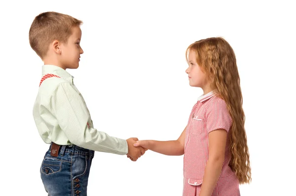 Niño y niña estrechando las manos entre sí Imagen de archivo