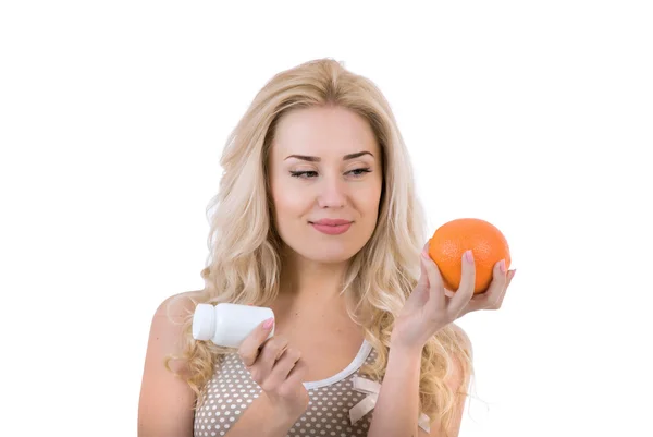 Menina com laranja e medicina em um fundo branco — Fotografia de Stock