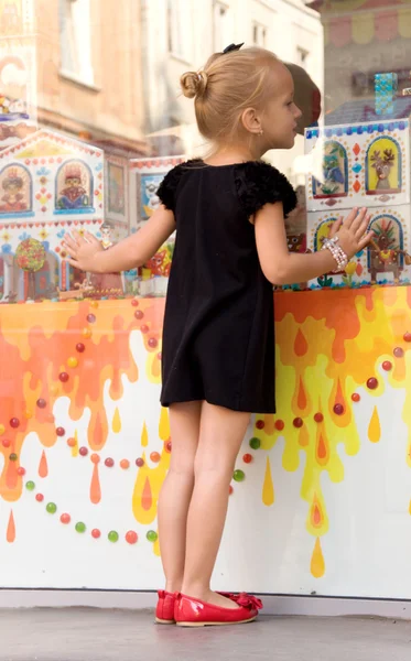 Menina olha para uma vitrine — Fotografia de Stock