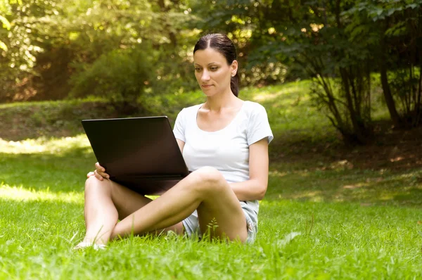 Mujer que trabaja por cuenta propia. haciendo trabajo en el parque —  Fotos de Stock