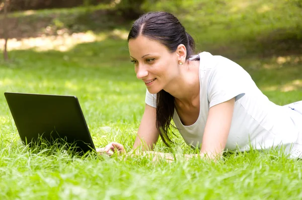 Meisje freelancer doet haar werk in het park — Stockfoto