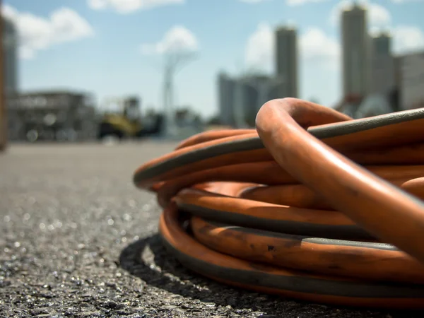 Den Orange förlängningssladden på marken på Constructionsite — Stockfoto