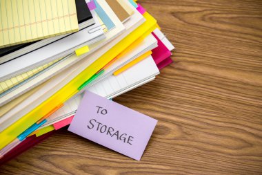 Depolama birimine; Masanın üzerindeki iş belgeler yığını