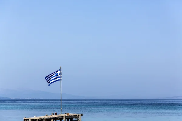 Griechische Flagge auf blauem Meer und Himmel Hintergrund Stockbild