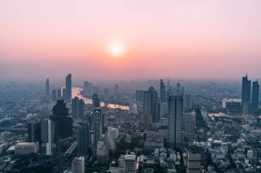 Gökdelenden gün batımında Bangkok manzarası Chao Praya nehri ve şehir manzarasına bakıyor..