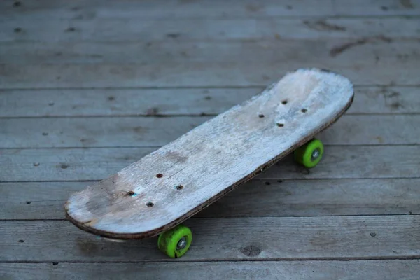 Starý Ošuntělý Dřevěný Skateboard Šedé Barvy Zelenými Koly Pozadí Desek — Stock fotografie