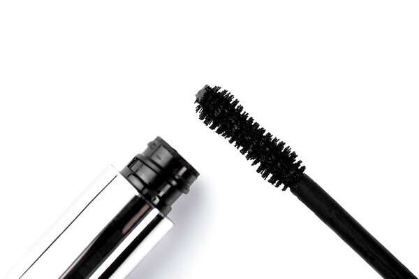black mascara in a silver bottle on a white isolated background.