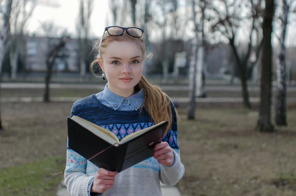 Retrato menina com livro no parque — Fotografia de Stock