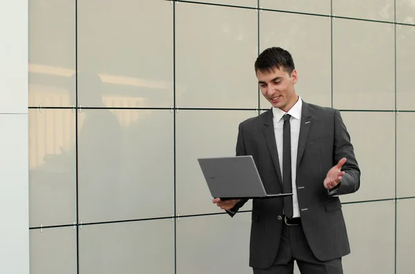 Homem de negócios com laptop perto do edifício — Fotografia de Stock