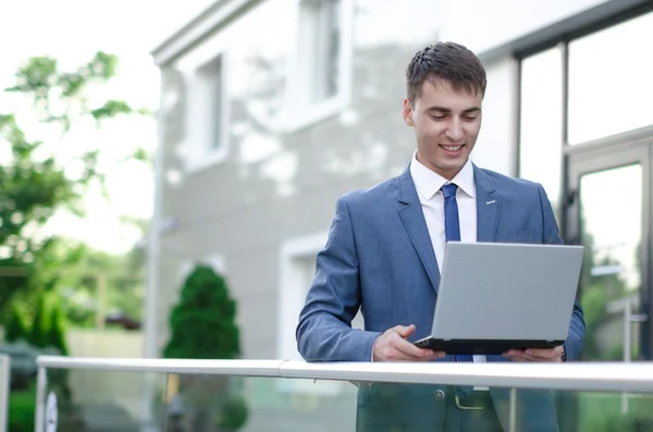 Empresário sorridente com laptop — Fotografia de Stock