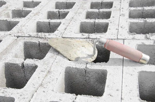 Trowel di cinderblock latar belakang abu-abu. dengan latar belakang batu bata adalah trowel — Stok Foto