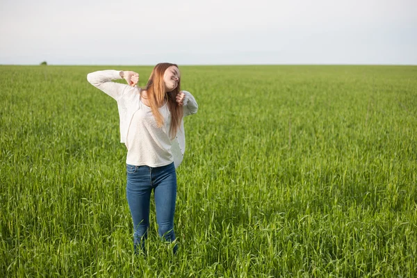 Woman with open arms in the green wheat field at the morning — Stock Photo, Image