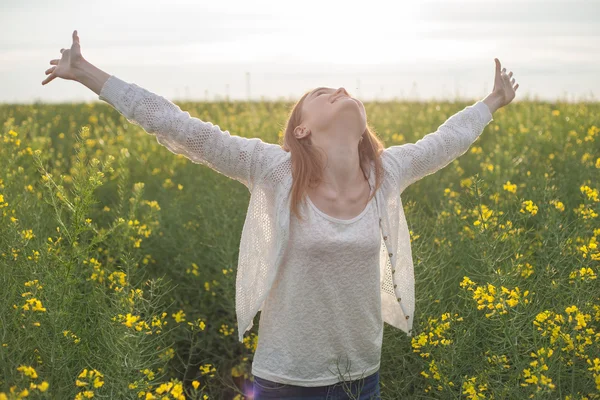 Woman with open arms in the green rapseed field at the morning Royalty Free Stock Photos