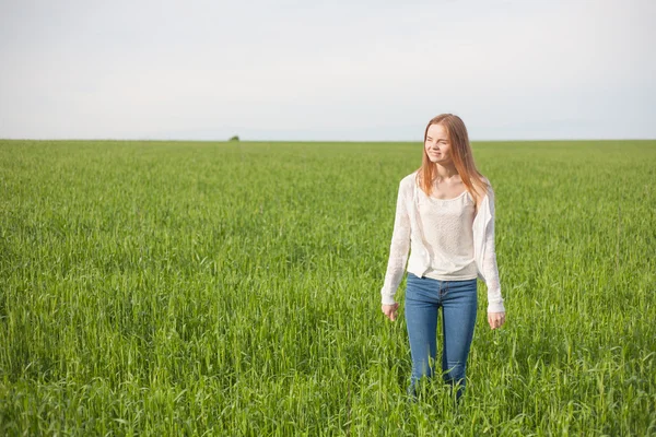 Frau mit offenen Armen im grünen Weizenfeld am Morgen. — Stockfoto