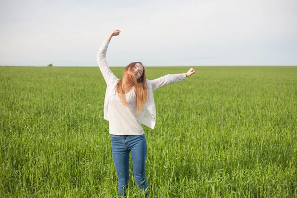 Femme à bras ouverts dans le champ de blé vert le matin . — Photo