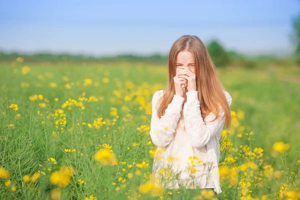 Аллергия на пыльцу, девушка чихает на рапсовом поле цветов . — стоковое фото