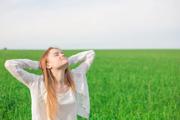 Vrouw met open armen op het gebied van de groene tarwe op de ochtend — Stockfoto