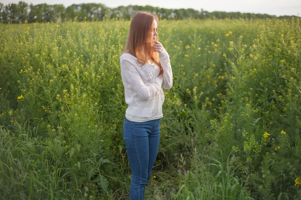 Alergia al polen, niña estornudando en un campo de colza de flores —  Fotos de Stock