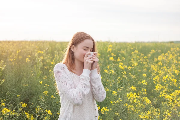 Pollenallergie, Mädchen niesen im Rapsfeld — Stockfoto