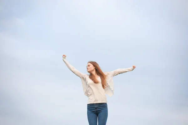 Femme à bras ouverts dans le ciel en arrière-plan le matin . — Photo