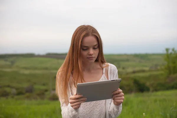 Jonge lachende vrouw met laptop in park. — Stockfoto