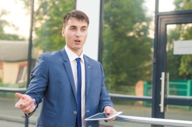 sol elinde dizüstü bilgisayar ile çalışma ve tartışmaya genç işadamı.