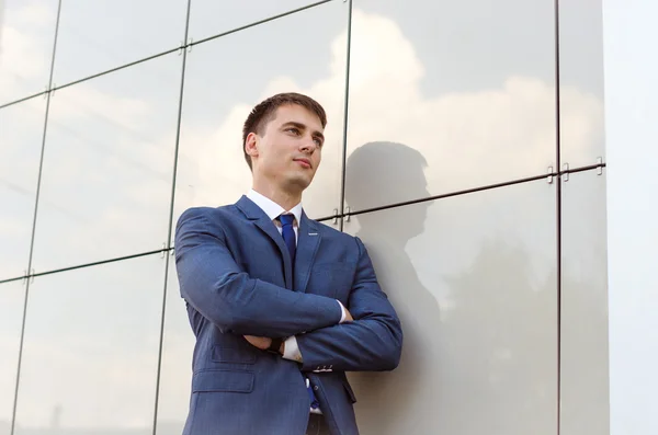 Jovem economista homem de sucesso em pé no interior do escritório moderno, homem confiante vestido com roupas corporativas de luxo usando tablet digital durante a pausa para o trabalho . — Fotografia de Stock