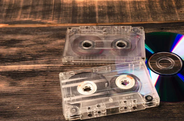 Vinyl disc and cassette tapes on the wooden table. — Stock Photo, Image