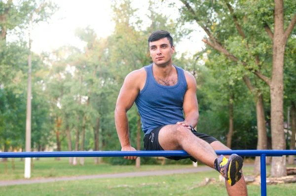Fitness, deporte, ejercicio, entrenamiento y el concepto de estilo de vida - joven haciendo tríceps inmersión en barras paralelas al aire libre . — Foto de Stock
