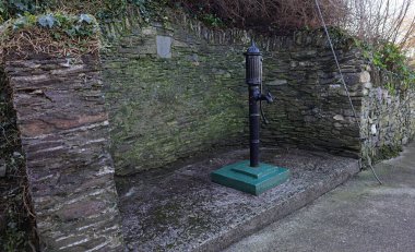 New Ross, İrlanda 'da bir yan yolda kaldırıma monte edilmiş eski bir su pompası..