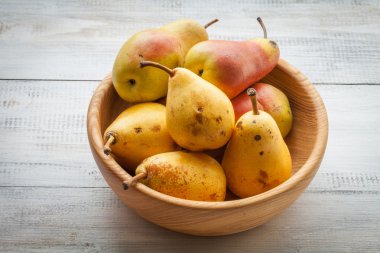 Beyaz ahşap bir masa üzerinde taze olgun organik armut
