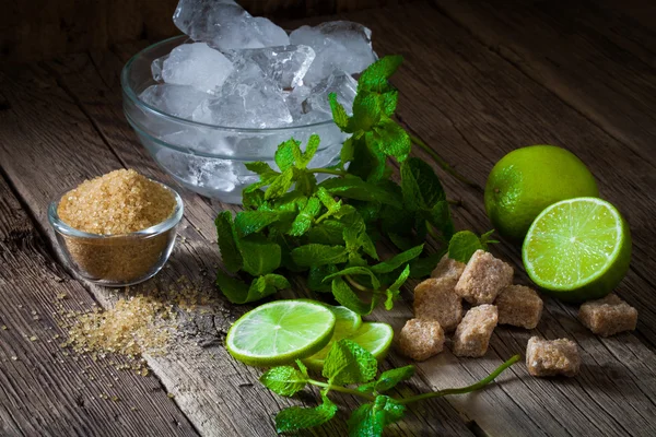 Ingredientes para hacer mojitos de hielo, hojas de menta y lima en añejo —  Fotos de Stock