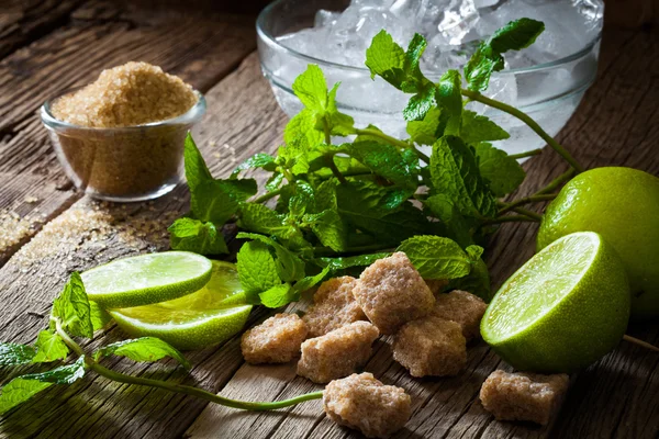 Ingrediënten voor het maken van mojito's ijs, blaadjes munt en limoen op oude — Stockfoto