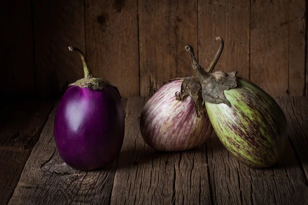 Berinjelas em uma mesa de madeira rústica . — Fotografia de Stock