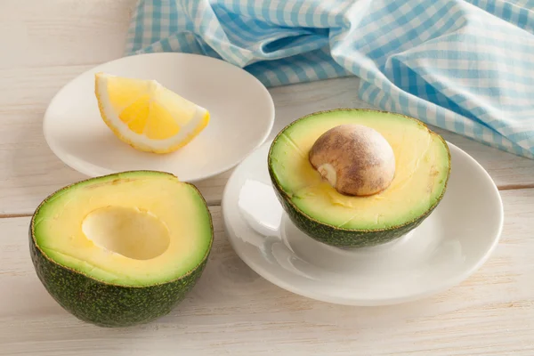 Halved organic avocado with core — Stock Photo, Image
