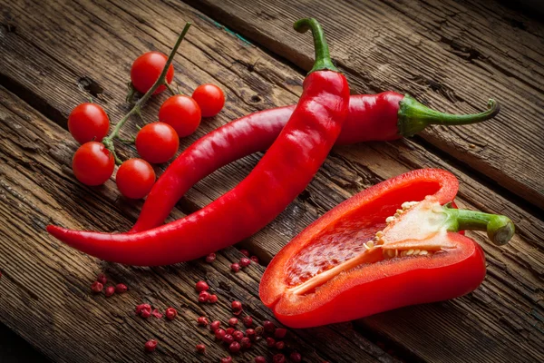 Red hot chili peppers słodki pieprz na drewnianym stole — Zdjęcie stockowe