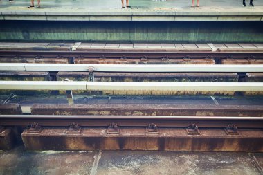 Tren istasyonundaki tren rayları. İşten sonra ofis çalışanlarının bacaklarıyla.