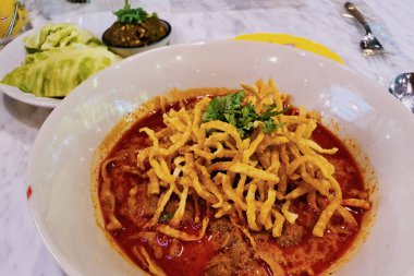 Kuzey Tayland körili şehriyesi, Kao soi, sebze ve biber ezmesi ile servis edilir.