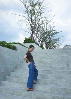 Merdivenlerde kameraya gülümseyen bir kadın..