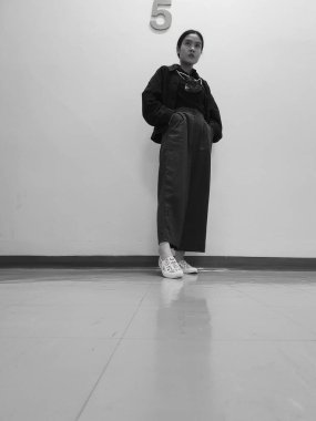 Asyalı bir ofis çalışanı yemek molasında 5. katta duruyor.