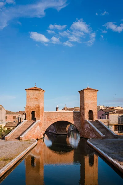 Comacchio, İtalya 'daki Trepponti Köprüsü, bulutlu mavi gökyüzü, su yansımaları