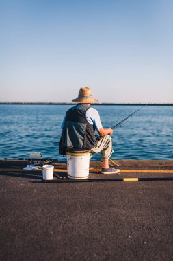 Marina di Ravenna, Emilia Romagna - İtalya Ağustos 2020: Zaccagnini iskelesinde arkadan görülen bir balıkçının portresi