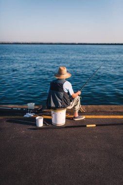 Marina di Ravenna, Emilia Romagna - İtalya Ağustos 2020: Zaccagnini iskelesinde arkadan görülen bir balıkçının portresi